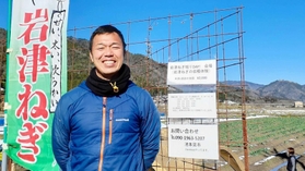 隔週土日に「岩津ねぎ掘りＤＡＹ！」を開く池本晃市さん。右奥の山の頂に竹田城が見える＝朝来市内