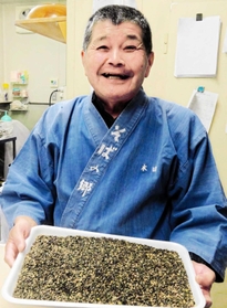 焼き畑跡で栽培した赤花そばの実について話す本田重美さん（２０１６年）