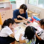 「上手やね」。幼稚園の預かり保育で優しく園児を見守る保育士＝神戸市垂水区瑞ケ丘