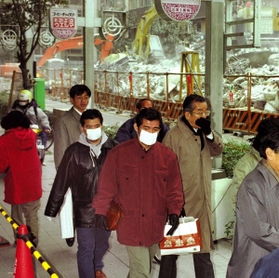 阪神・淡路大震災後、ビル解体現場近くでは粉じんが舞い、マスクなどで口を覆う人たちもいた＝神戸市中央区（１９９５年１月３１日）
