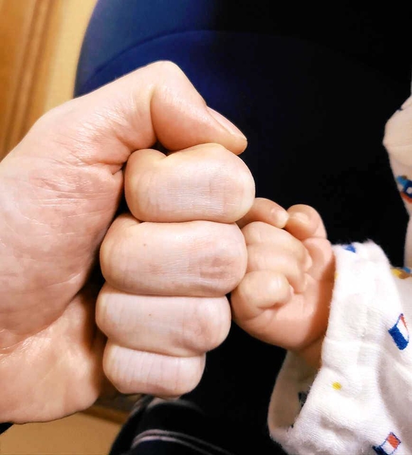 父と子の手と手。男性も育休で絆を深められる＝洲本市内