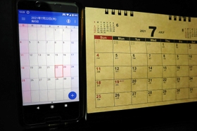 祝日の移動が急きょ決まったため、間に合わずに作製されたカレンダー（右）。スマホでは更新されて正しい日にちとなっている