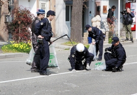 路上に散乱した乗用車の部品などを拾い集める警察官ら＝５日午後１時５５分、神戸市中央区割塚通６