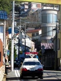 事件現場となった弘道会の関連施設周辺で警戒するパトカー＝２１日午前８時３４分、神戸市中央区熊内町９