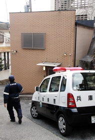 室内が荒らされた山口組系暴力団事務所を警戒する警察官＝２０日午前８時５３分、神戸市須磨区妙法寺