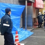 　トラックが突っ込んだ神戸山口組系事務所の前で警戒する警察官＝１６日午前、大阪府守口市