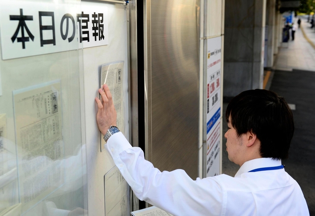 神戸山口組を指定暴力団とすることを公示する官報を張り出す国立印刷局の職員＝15日午前８時30分、東京都港区