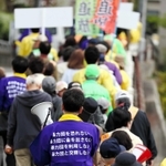 「暴力団は出て行け」。山口組直系団体の拠点施設の立ち退きを求め、地域を行進した住民ら＝３日、神戸市長田区