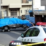 乗用車が衝突した●友会事務所の玄関付近を調べる兵庫県警の捜査員ら。衝突した乗用車はブルーシートに包まれ、レッカー移動された＝１１日午前８時３０分、淡路市志筑（注）●は「侠」の右が「夾」
