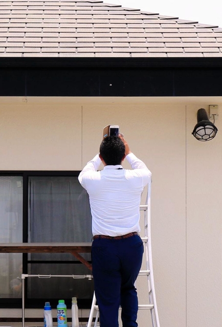 銃弾の跡とみられる穴を調べる捜査員ら＝２０日午前、稲美町中村