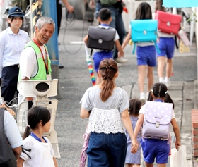 警察官らが見守る中、保護者と一緒に下校する児童ら＝１２日午後、神戸市長田区前原町１