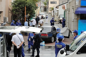 発砲事件があったとみられる現場付近を調べる警察官ら＝１２日午前、神戸市長田区五番町