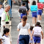 警察官らが見守る中、保護者と一緒に下校する児童ら＝１２日午後、神戸市長田区前原町１