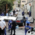 発砲事件があったとみられる現場付近を調べる警察官ら＝１２日午前、神戸市長田区五番町