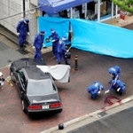 事件に関わったとみられる車の周囲を調べる捜査員ら。右下の路面には血痕のようなものが見える＝神戸市長田区五番町