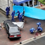事件に関わったとみられる車の周囲を調べる捜査員ら。右下の路面には血痕のようなものが見える＝１２日午前１１時１２分、神戸市長田区五番町