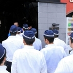 一勢会の事務所の捜索に入る捜査員＝２２日午前９時５６分、岡山市北区柳町