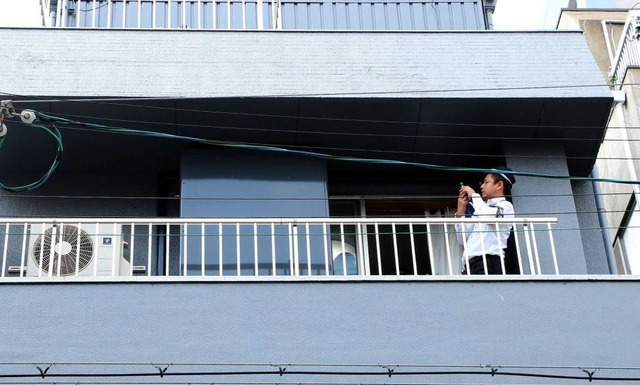 建物のベランダを調べる捜査員＝１１日午前、神戸市中央区二宮町３