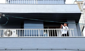 建物のベランダを調べる捜査員＝１１日午前、神戸市中央区二宮町３