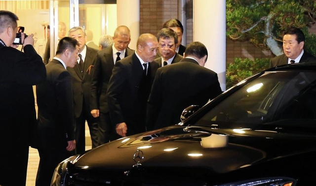 山口組の直系組長の通夜に出席後、葬儀場から出る篠田建市組長（中央）ら＝１７日午後６時３７分、神戸市北区