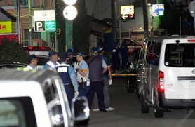 発砲事件があった現場周辺を調べる警察官＝２１日午後８時３分、神戸市中央区熊内町９