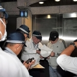 弘道会の拠点前で仮命令書を示す捜査員ら＝１１日午後９時３５分、神戸市中央区熊内町９