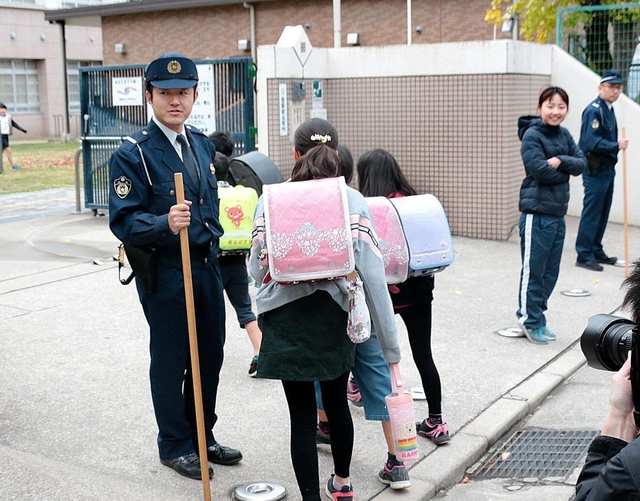 射殺事件を受け、児童の登校を見守る警察官ら＝２８日午前、尼崎市内