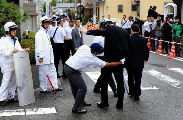 定例会に集まった任侠山口組の組員にボディーチェックをする兵庫県警の捜査員＝２０１８年９月、尼崎市東難波町４