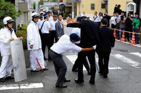 定例会に集まった任侠山口組の組員にボディーチェックをする兵庫県警の捜査員＝２０１８年９月、尼崎市東難波町４