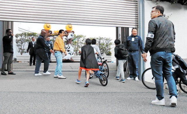 ハロウィーンの菓子をもらうため、山口組総本部に入っていく子どもら＝２０１８年１０月３１日、神戸市灘区篠原本町４